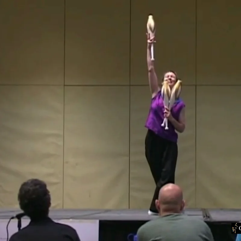 Cindy Marvell holding a club high after her act, audience in the front row