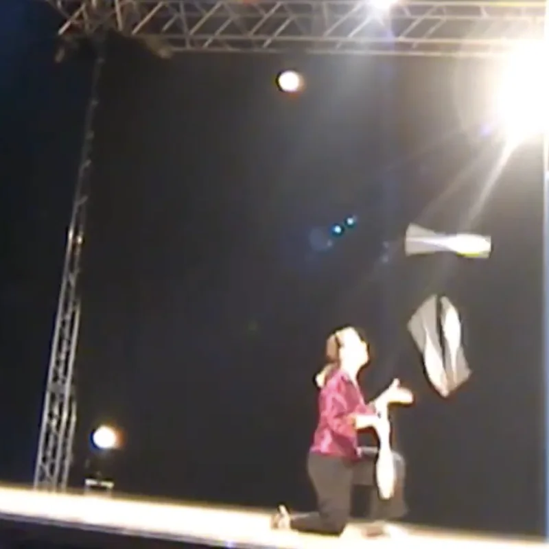 Cindy Marvell juggling on an outdoor festival stage under stage lights